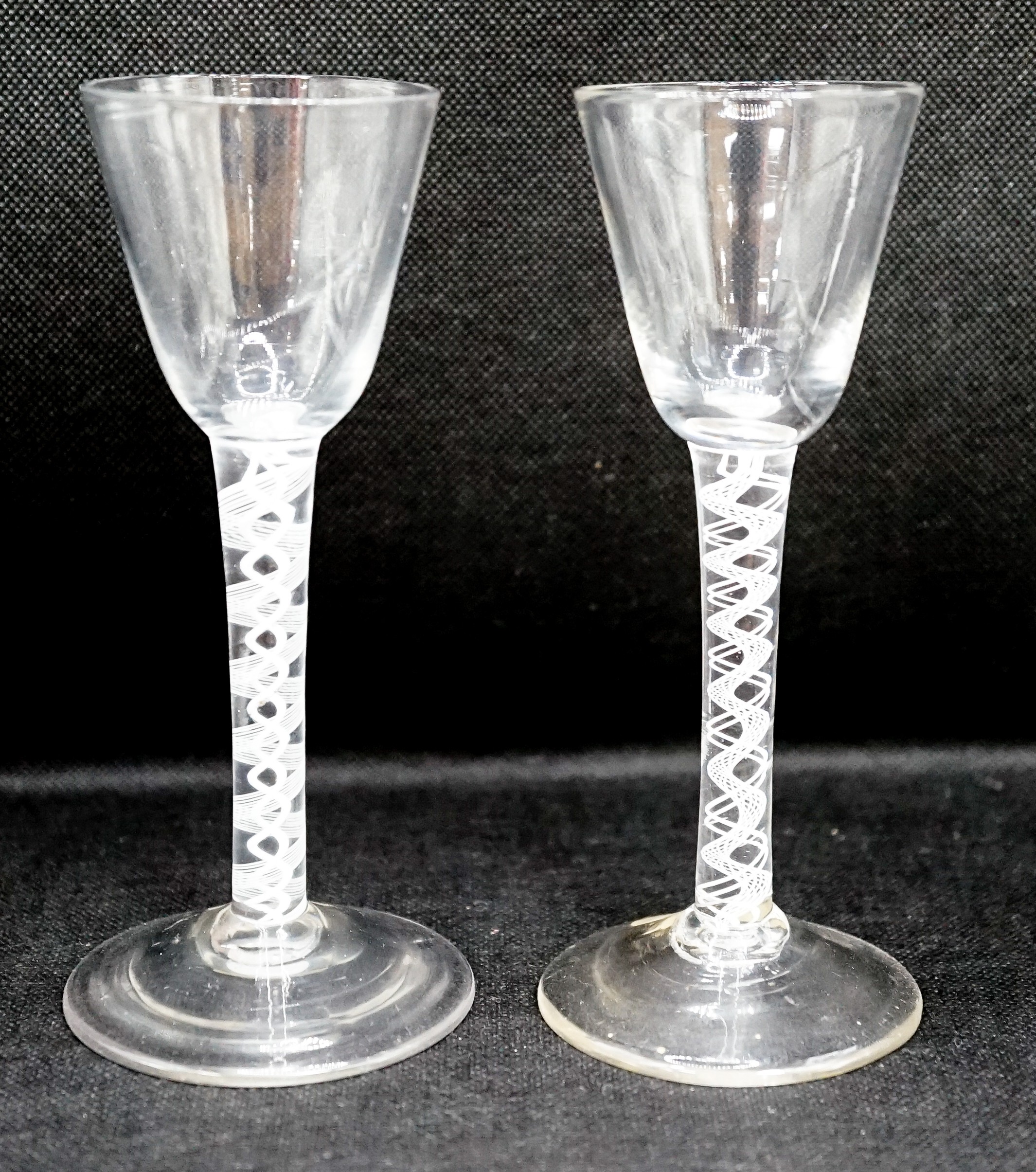 Two George III double series opaque twist stem cordial glasses, c.1765, each with a funnel shaped bowl, 15cm